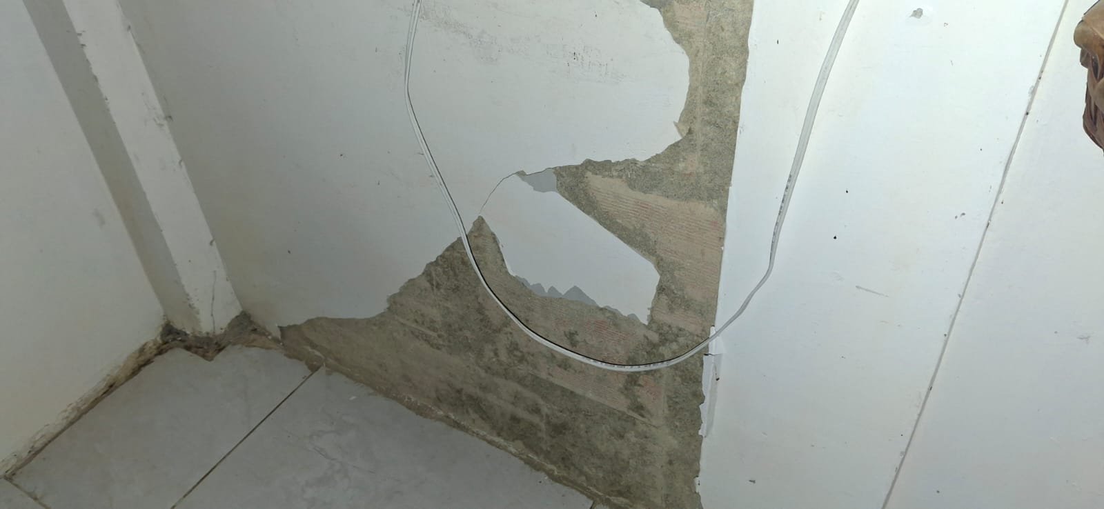 Hueco en la esquina de una pared con cableado expuesto